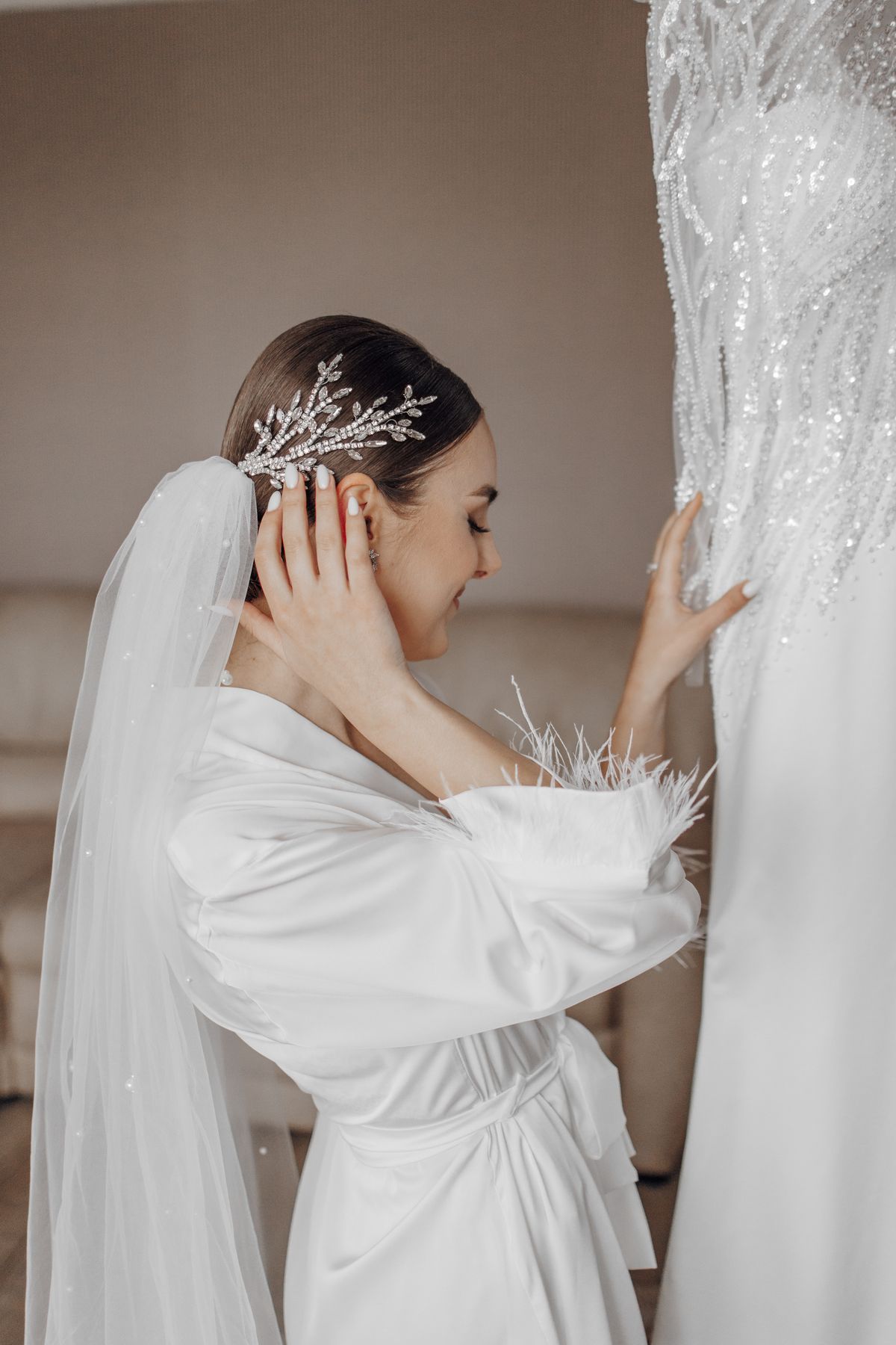 Bride getting ready, reaching for her wedding dress